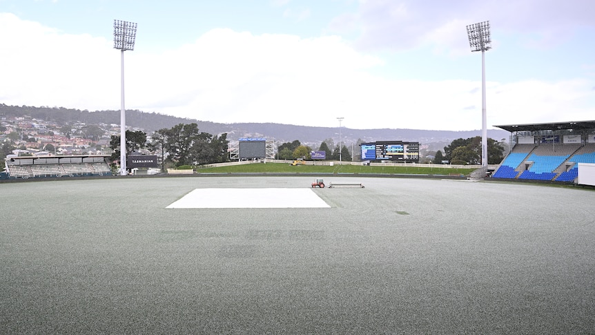 Hail covers the outfield at Bellerive Oval, making it appear white around the covered wicket block