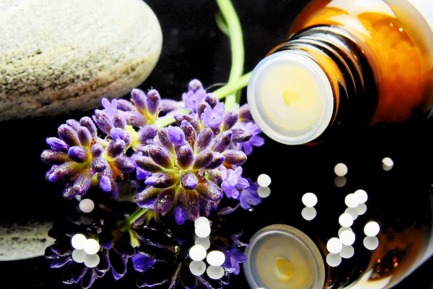 Flowers and a bottle filled with pills