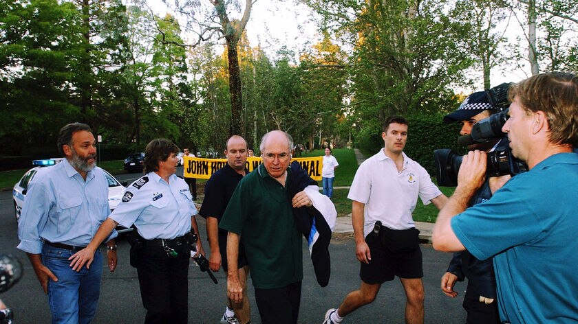 Greenpeace anti-war protestors greet John Howard as he returns from his morning walk by blocking both entrances of The Lodge in Canberra, March 19, 2003. The protest lasted for nearly 3 hours.