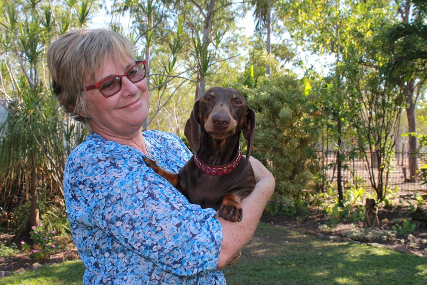 Melissa Purick holding her dachshund Tim Tam in her arms and looking on like a proud mum