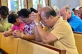 People pray in church on their knees 