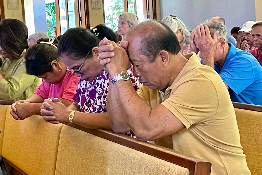 People pray in church on their knees 