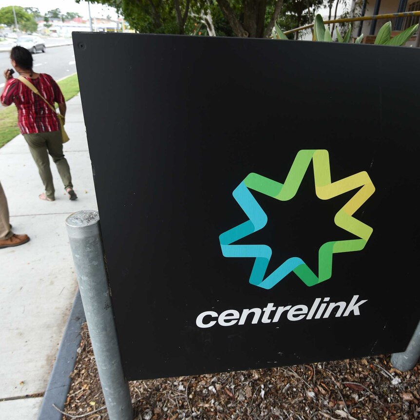People stand outside a Centrelink office.