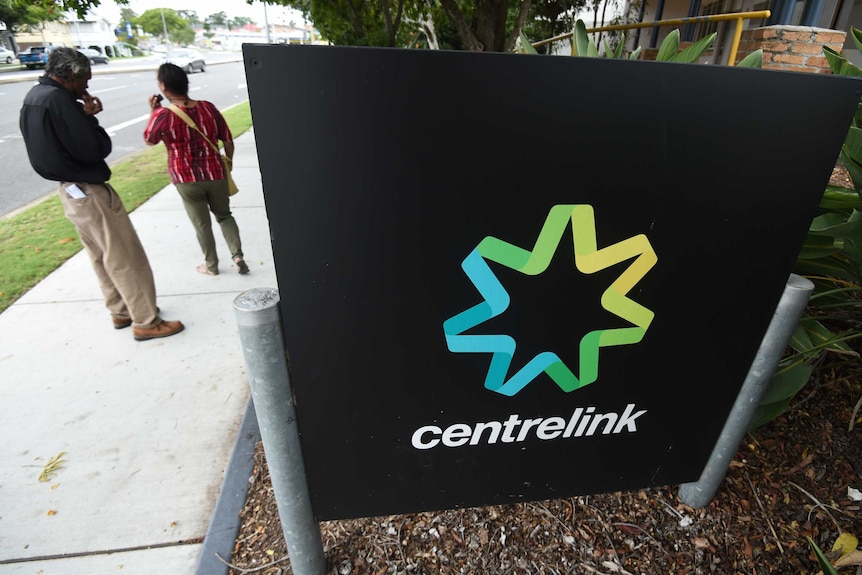 People stand outside a Centrelink office.