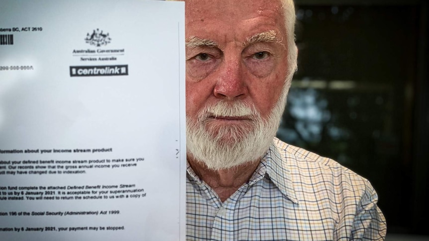 Man holds up letter from Centrelink