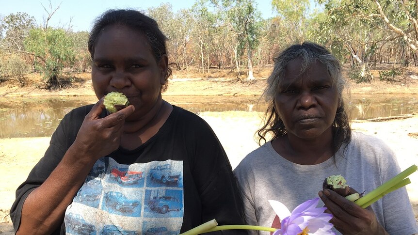 Two women eat lilly bulbs