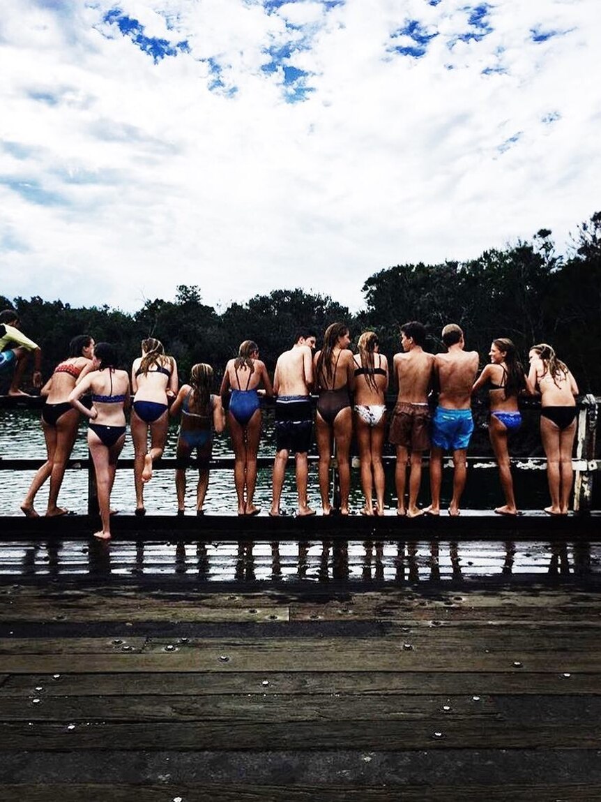 Line of kids on bridge ready to jump in