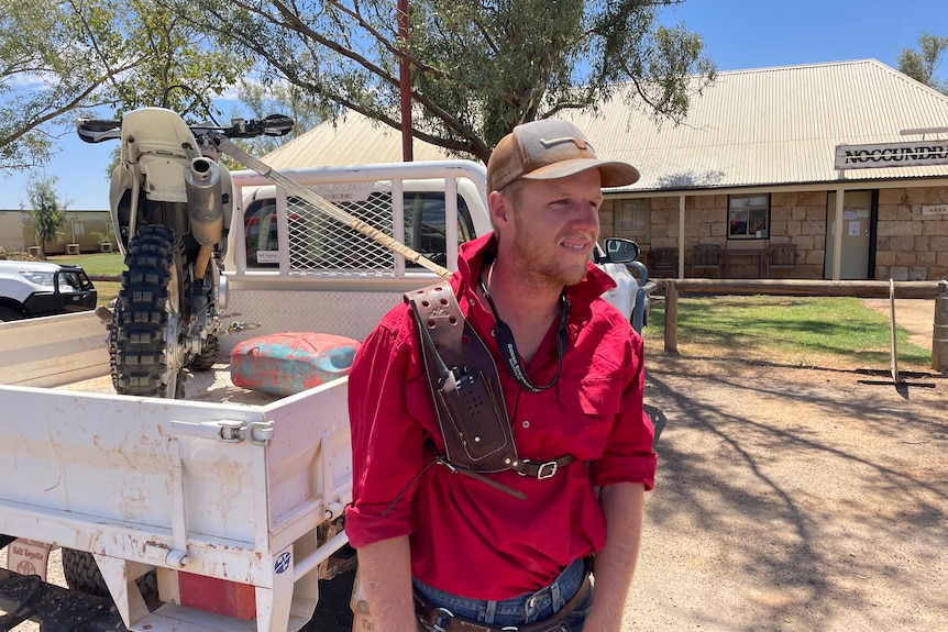 Man standing in front of ute with motorbike in try