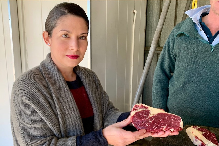 Analiese Gregory and Ben Geard stand beside a wood block cutting vintage beef.