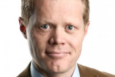 A photo portrait of a man in a shirt, tie and jacket.