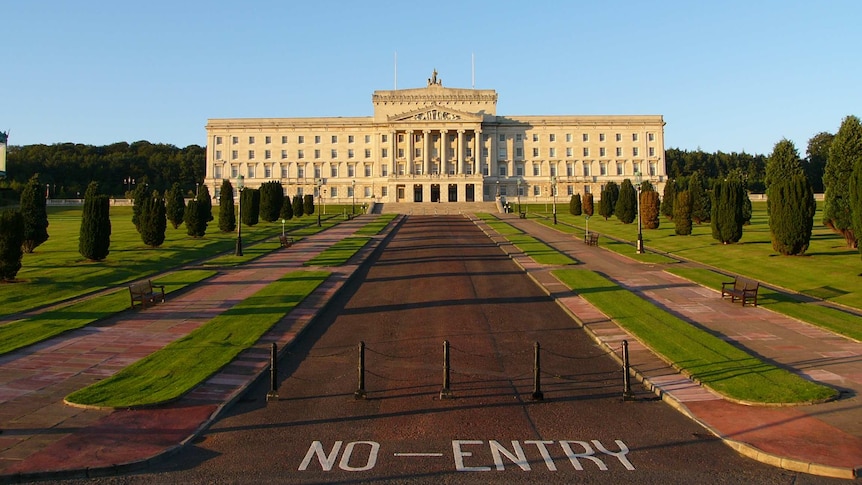 From a far distance, you see a large ceremonial avenue leading toward a neoclassical building in the Greek style.