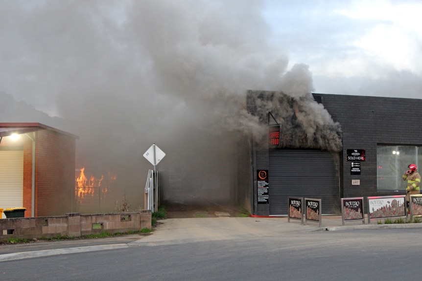 Flames and smoke pour out of a building in New Norfolk.