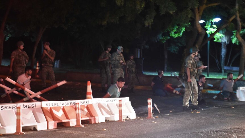 Turkish security officers detain unknown individuals on the side of the road in Istanbul