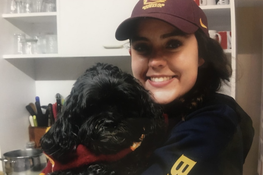 Georgie Tunny in Brisbane Broncos gear with her dog.