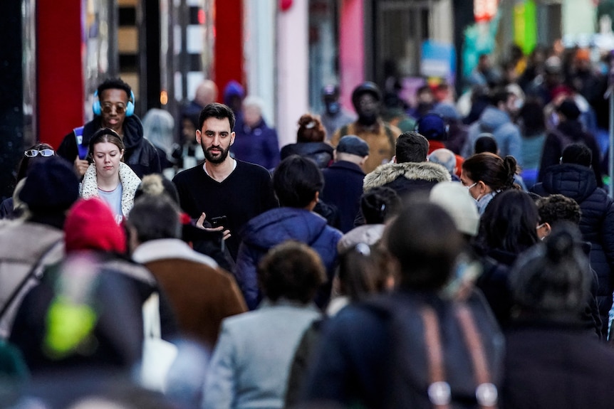 People walk in a crowd on a New York City street.