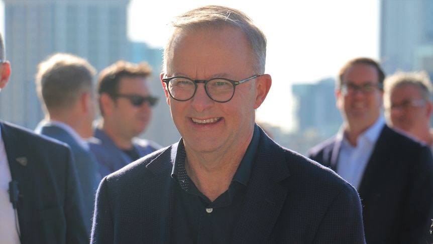 PM Anthony Albanese smiling while speaking to reporters in Perth