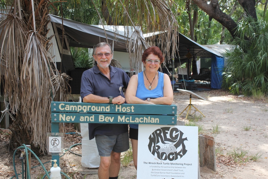 A man and a woman standing behind a camp ground entrance sign at Wreck Rock beach