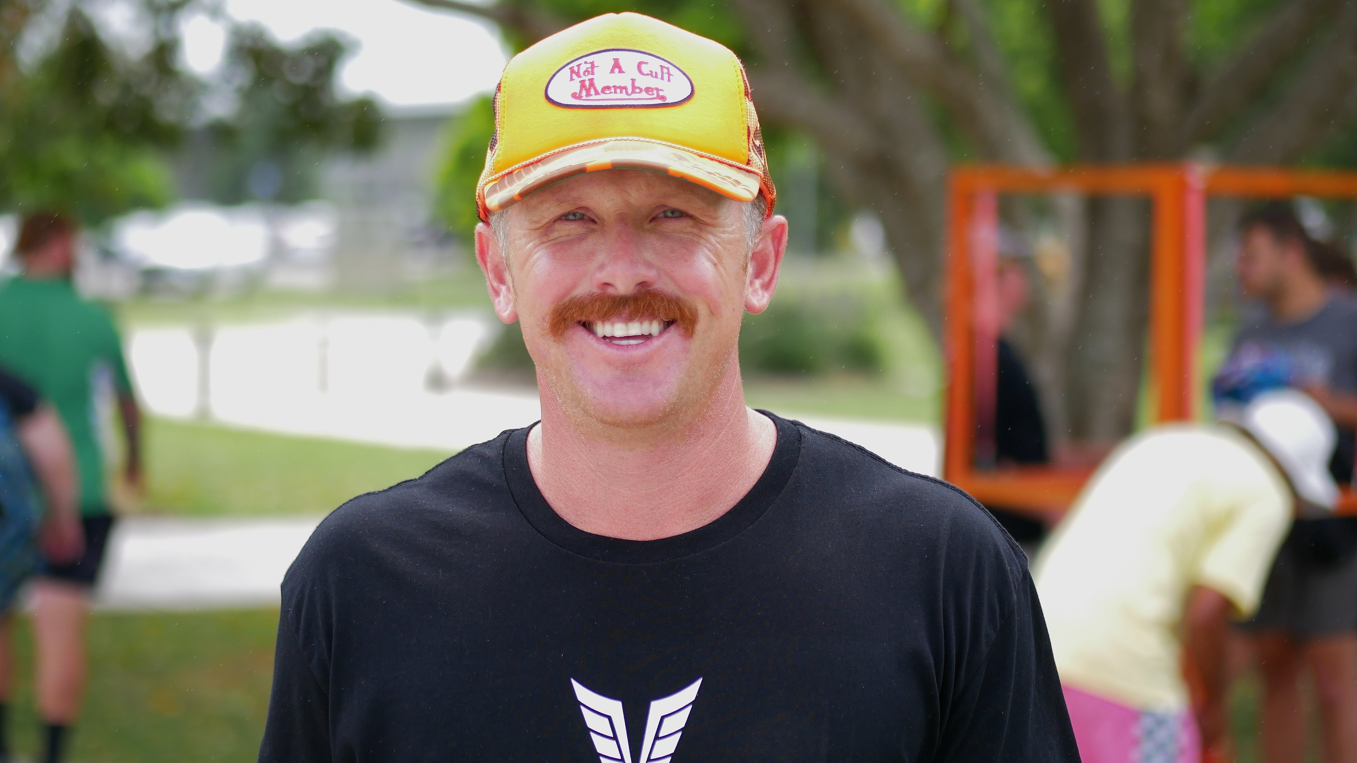 Homem branco com boné de beisebol e camiseta preta