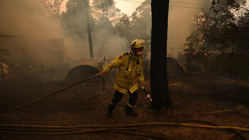 NSW RFS crews work to protect a property in Kulnura from the Three Mile fire.