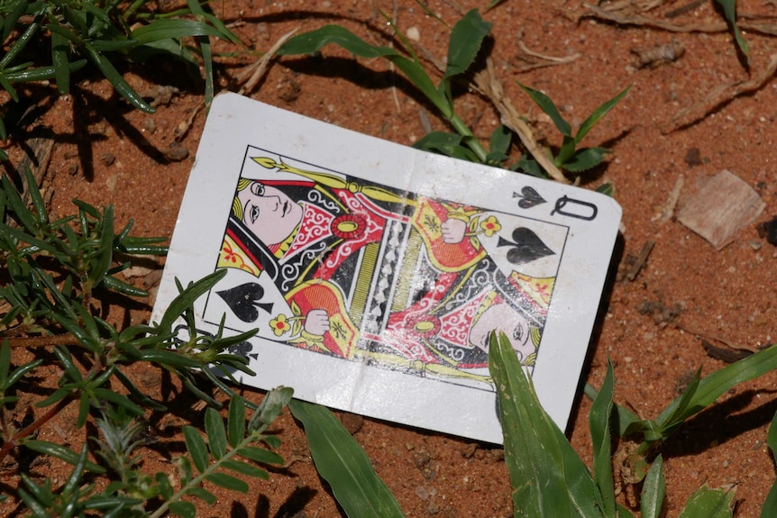 a playing card lying in the dirt
