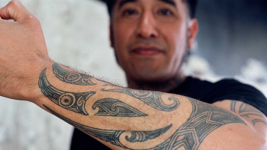 A Maori man shows a traditional Moko tattoo on his arm.