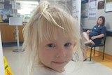 Toddler with blonde hair, dark blue eyes.