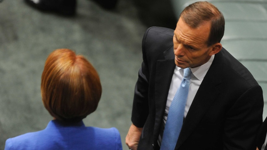 Tony Abbott walks past Julia Gillard during Question Time on October 9, 2012.