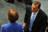Tony Abbott walks past Julia Gillard during Question Time on October 9, 2012.