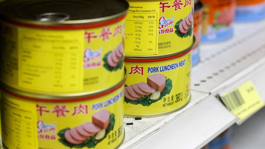 Brightly coloured tins of pork luncheon meat.