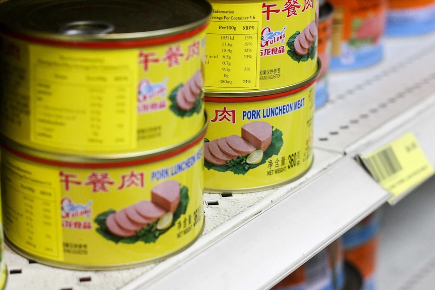 Brightly coloured tins of pork luncheon meat.