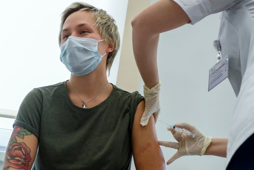 一名俄罗斯医务人员在莫斯科将一剂人造卫星 V 疫苗注射到一个人的手臂上