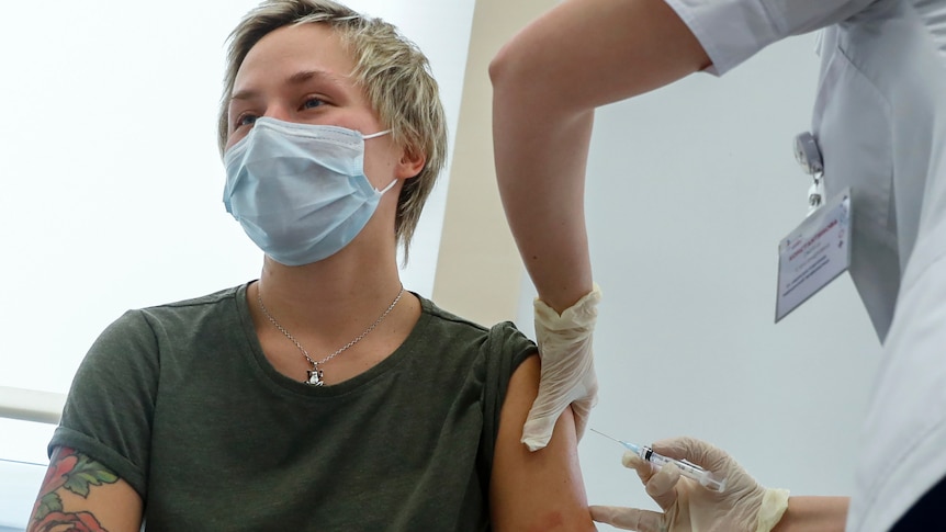 a russian medical workers administers a shot of Sputnik V vaccine to a person's arm in Moscow