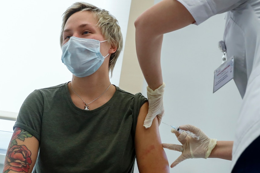 Un lucrător medical rus dă o doză din vaccinul Sputnik V brațului unei persoane la Moscova