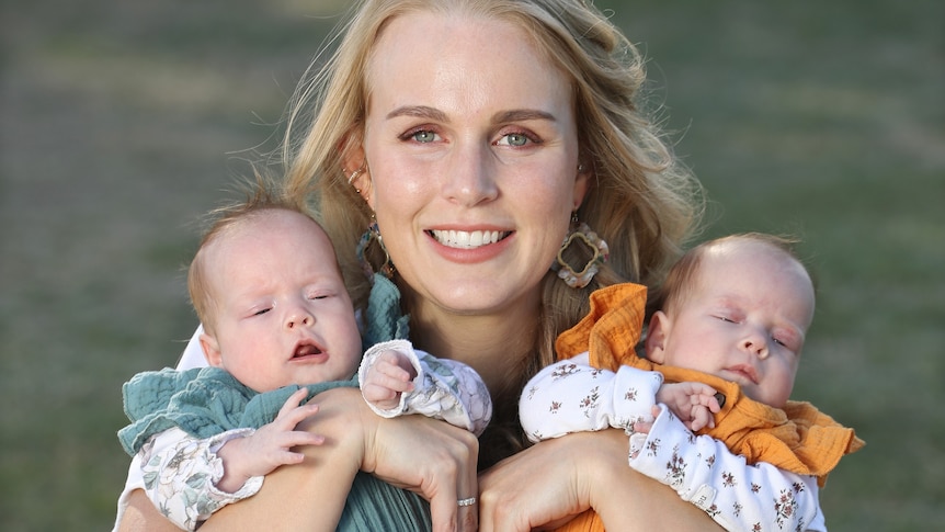 Kristen Meadows and her twin girls in her arms.