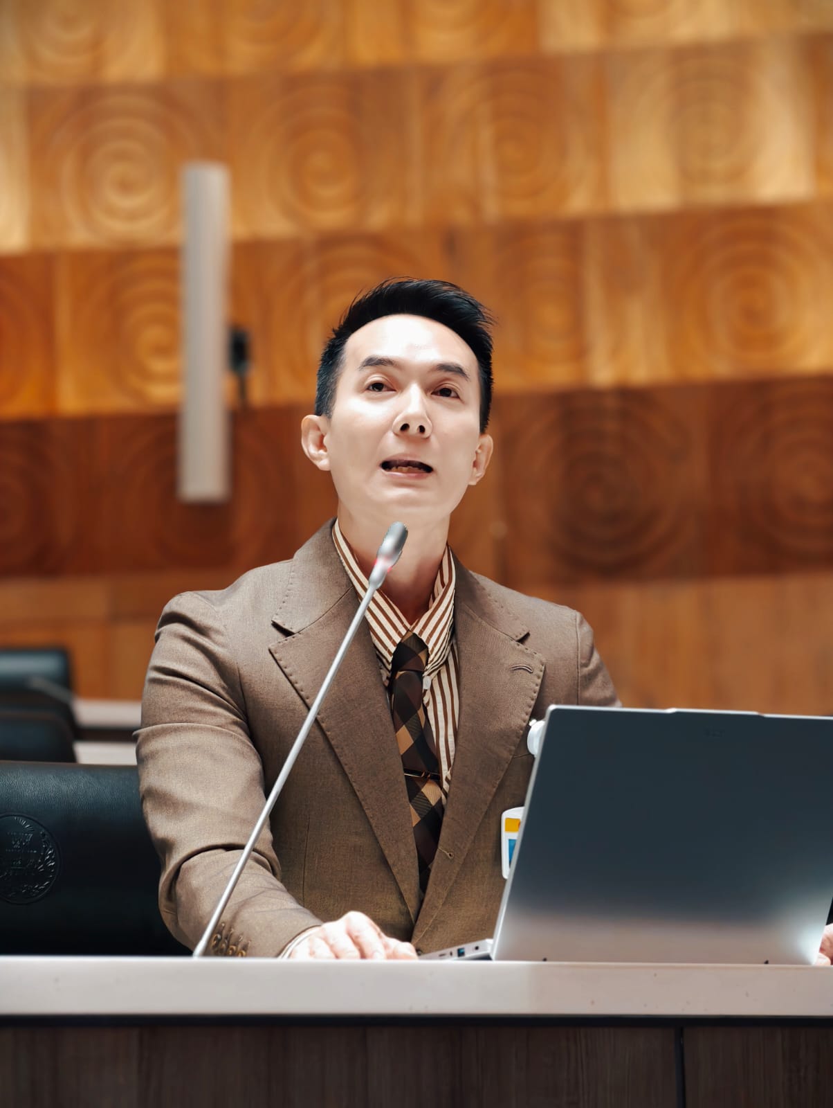 Un hombre habla por un micrófono en un atril del Parlamento.