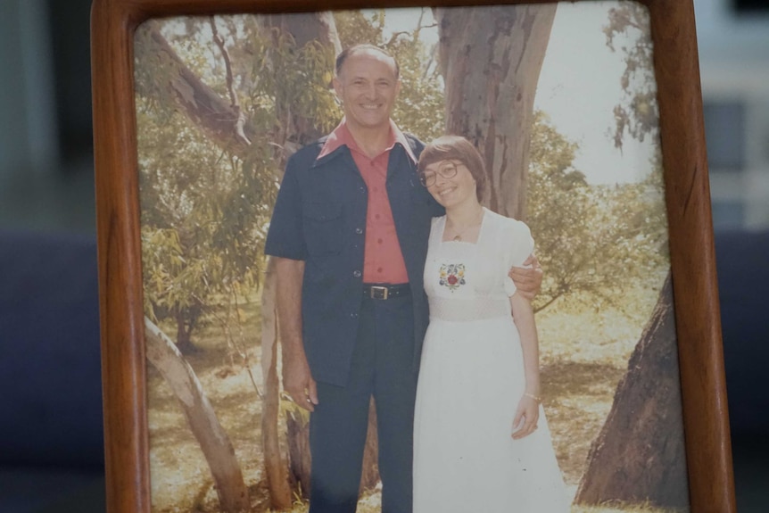 Judy and Bob Dent in an older photo. He is wearing a navy suit and she is wearing a long white dress.