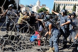 Protesters and riot police clash in barb wire on the street in Lebanon.