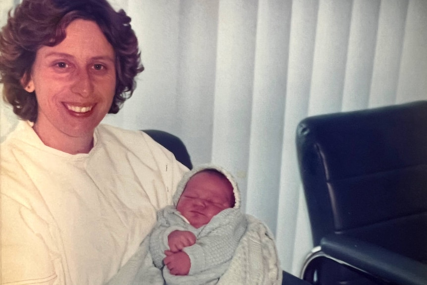 Adelaide nurse Linda Campbell holding a baby.