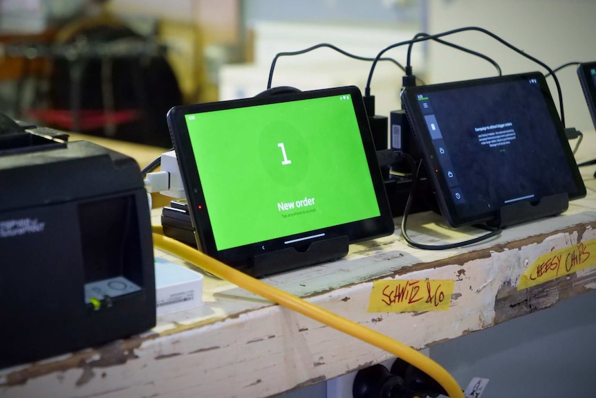 Tablet computer screens lined up on a bench top