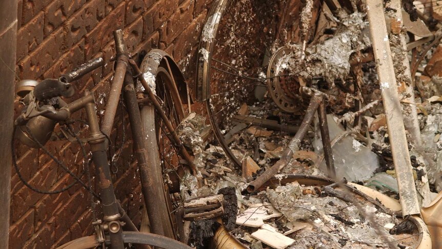 Part of a fire damaged house and two burnt bicycles in Chapman on January 18, 2003.