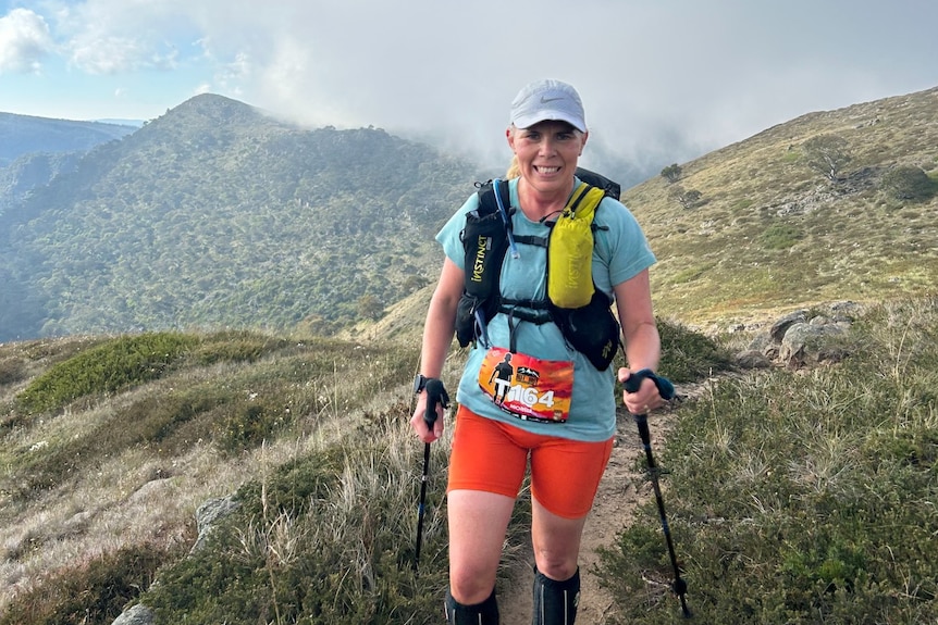 a woman wearing outdoor trail running equipment on a mountian.