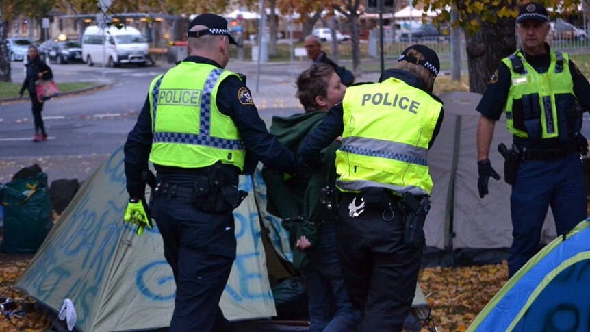 Woman is taken away from Parliament lawns homeless protest.