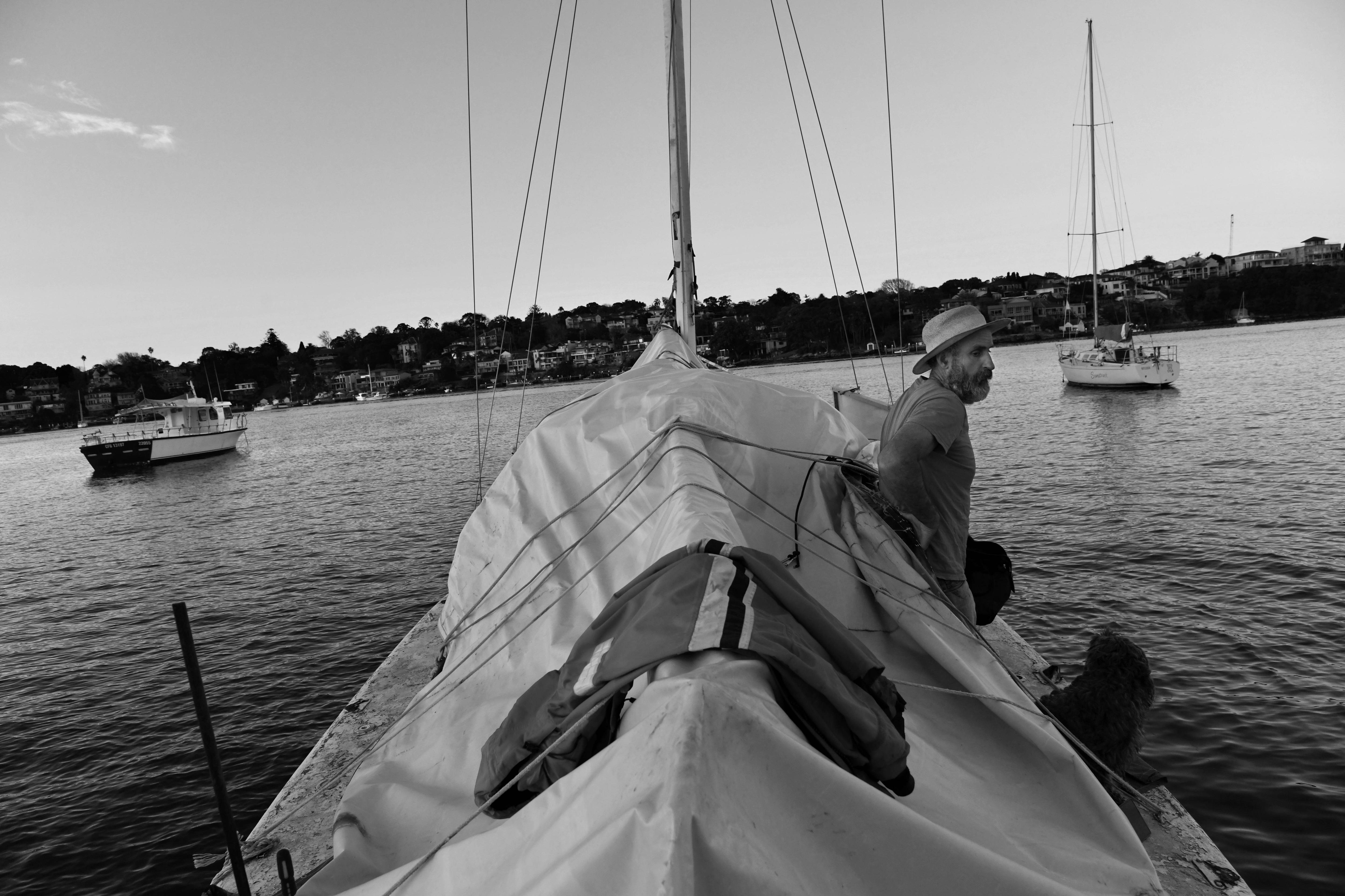 A man with a wide-brimmed hat sits on his boat 