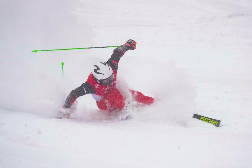 A skiier sends snow flying during a slalom run