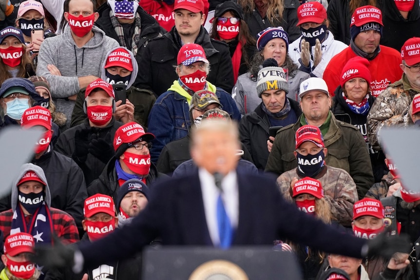 Supporters watch as President Donald Trump speaks during a campaign event