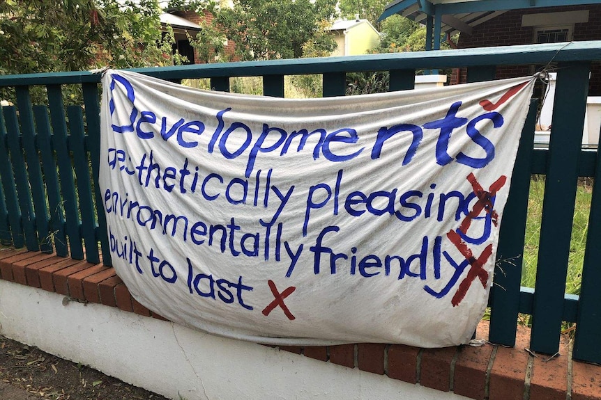 An anti-development banner hanging on a fence