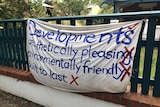 An anti-development banner hanging on a fence