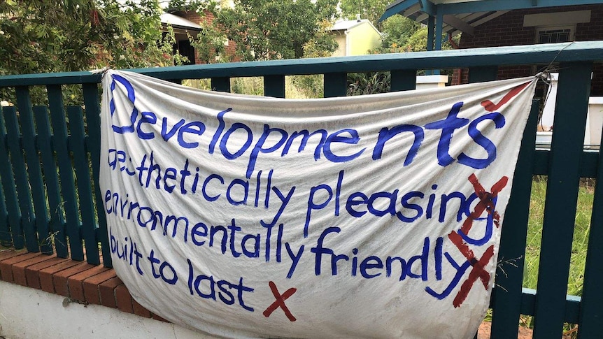 An anti-development banner hanging on a fence