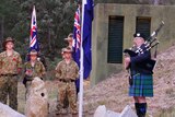 Army cadets and a musician outside of a historic world war two bunker for anzac day.