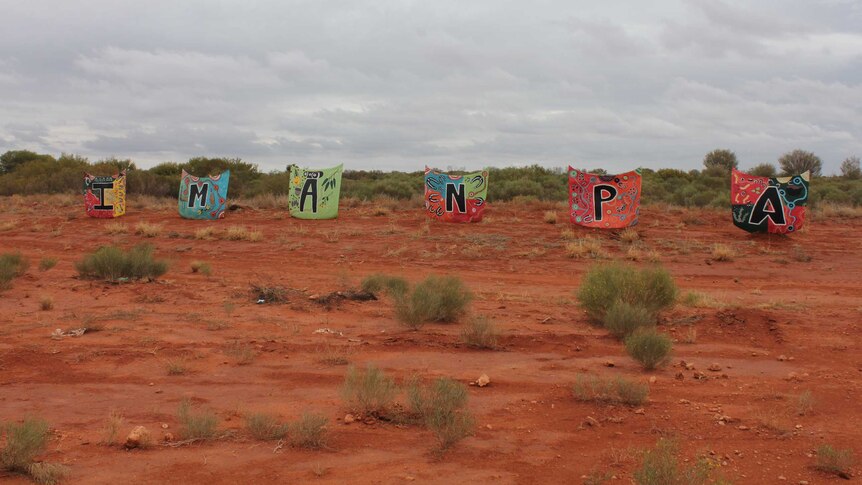Bringht letters spelling out Imanpa in the central desert.